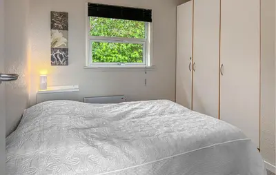 a white bedroom with a bed and a window at Awesome Home In Farsø With Sauna in Farsø