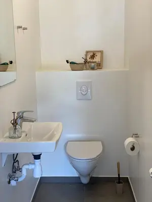 a white bathroom with a toilet and a sink at Staarup Hovedgaard in Højslev