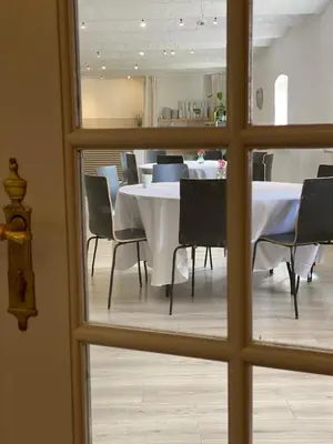 a dining room with a table and chairs through a window at Staarup Hovedgaard in Højslev
