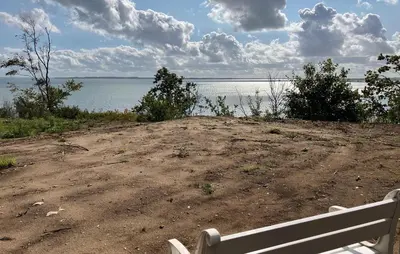 a bench sitting on the side of the water at 4 Bedroom Awesome Home In Thyholm in Thyholm