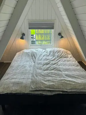 a large bed in a room with a window at Holiday Home At Himmerland Golf & Spa Resort in Farsø