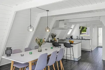 a kitchen and dining room with a table and chairs at Holiday Home At Himmerland Golf & Spa Resort in Farsø