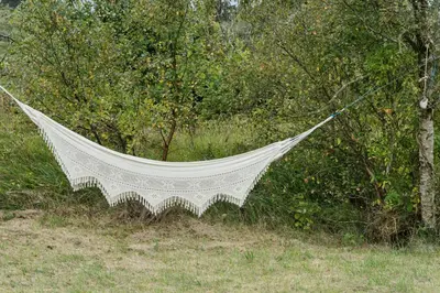 a white hammock in a field next to trees at Family House With Sea View In Svinkløv in Fjerritslev