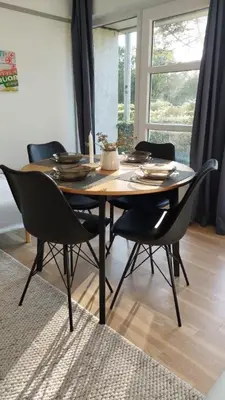 a dining room table with black chairs in a room at Antonia s quality apartment 1 in Viborg