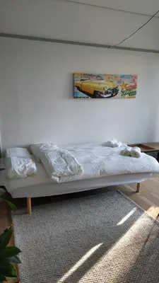a bed in a room with a picture on the wall at Antonia s quality apartment 1 in Viborg