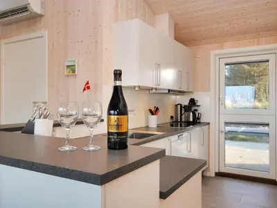 a bottle of wine sitting on a counter with two wine glasses at Holiday Home Arisa - 100m to the fjord by Interhome in Løgstør