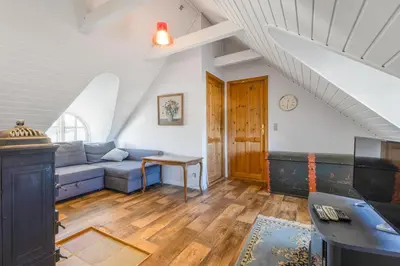 a living room with a blue couch and a table at 3007Møllehuset - Stuehus in Blokhus