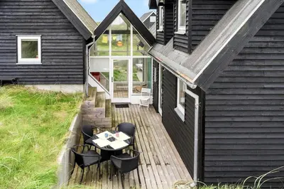a wooden deck with a table and chairs on a house at BL1120-Saltum-Kohlsvej-15 in Saltum