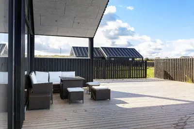 a patio with a table and chairs on a deck at LK2159-Lokken-Kringelbaekvej-27 in Løkken