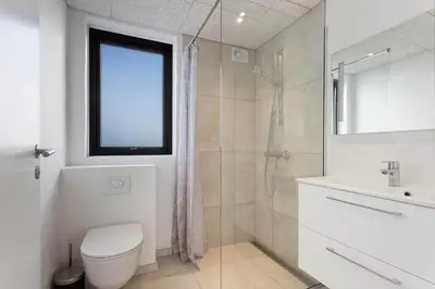 a bathroom with a toilet and a shower and a sink at LK2159-Lokken-Kringelbaekvej-27 in Løkken
