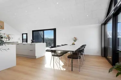 a kitchen and dining room with a table and chairs at LK2159-Lokken-Kringelbaekvej-27 in Løkken