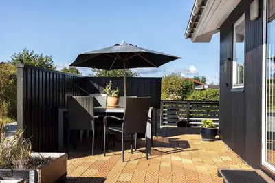 a table and chairs with an umbrella on a patio at LF14058-Roslev-Eskovvej-58 in Roslev