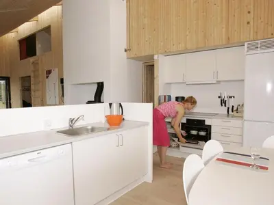 a woman standing in a kitchen with a stove at Holiday home in Thisted with swimming pool in Thisted