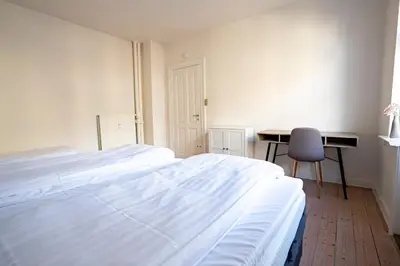 a bedroom with a bed and a desk and a chair at Holstebro Apartments in Holstebro