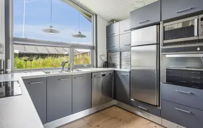 a kitchen with stainless steel appliances and a window at Beautiful Home In Blokhus With Sauna in Blokhus