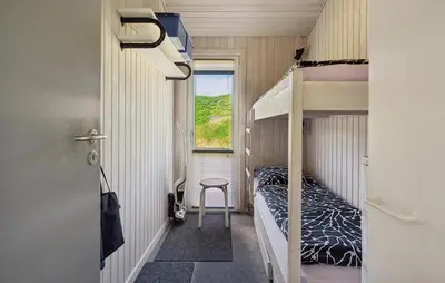 a small room with bunk beds and a table at Beautiful Home In Blokhus With Sauna in Blokhus