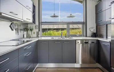 a kitchen with gray cabinets and a large window at Beautiful Home In Blokhus With Sauna in Blokhus