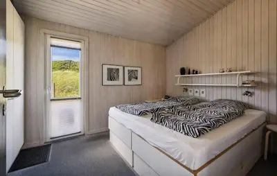 a bedroom with a zebra print bed and a window at Beautiful Home In Blokhus With Sauna in Blokhus