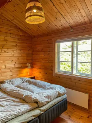 a bedroom with a bed in a wooden room at Authentic Wooden House By The North Sea in Vestervig