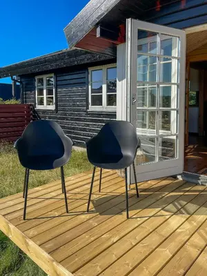 two chairs sitting on a deck in front of a house at Authentic Wooden House By The North Sea in Vestervig