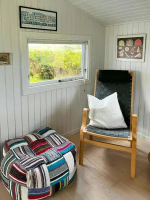 a bed and a chair in a room with a window at Family House Close To The Sea At Tranum Strand in Brovst