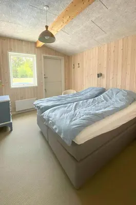 a bedroom with a large bed in a room at Holiday Home With Pool And Fjord Views On Lundø in Højslev