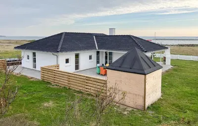 a small white house with a black roof at Cozy Home In Struer With Sauna in Struer