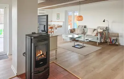 a living room with a fireplace in the middle of a room at Cozy Home In Struer With Sauna in Struer
