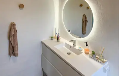 a bathroom with a sink and a mirror at Cozy Home In Struer With Sauna in Struer