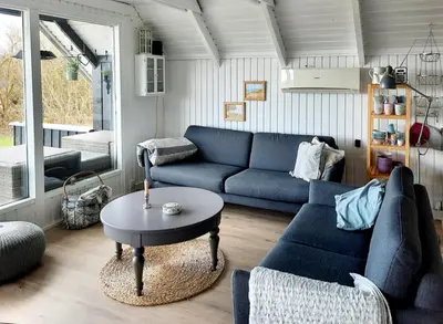 a living room with a blue couch and a table at Fjord Views And Spa By Limfjorden in Roslev