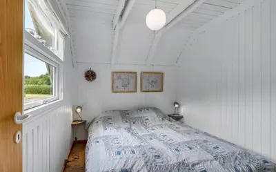 a bedroom with a bed in a room with a window at Fjord Views And Spa By Limfjorden in Roslev