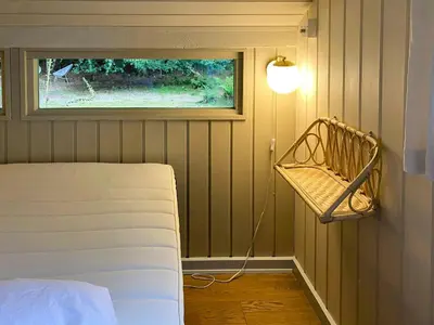 a room with a bed and a window and a lamp at Holiday Home Between Beach And Forest On Mors in Øster Assels