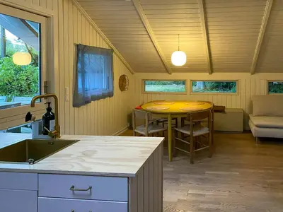 a kitchen with a sink and a table in a room at Holiday Home Between Beach And Forest On Mors in Øster Assels