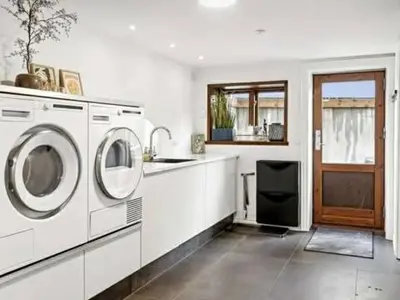 a kitchen with two washing machines and a sink at Østerbrogade 49 in Holstebro