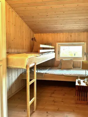 a bunk bed in a cabin with a window at Bright Holiday Home Close To Sea Near Blokhus in Blokhus