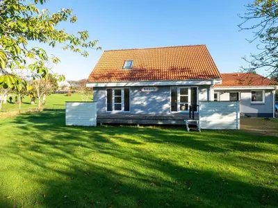a white house with a red roof in a yard at 4 star holiday home in Hanstholm in Hanstholm