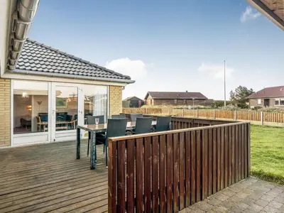 a wooden deck with a table and chairs on it at Holiday Home Gisa - 500m from the sea by Interhome in Thisted