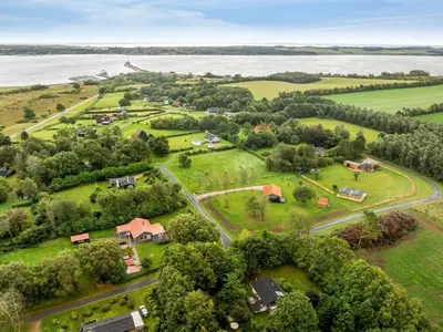 an aerial view of a village with trees and a lake at Holiday Home Velika - 300m to the fjord by Interhome in Roslev