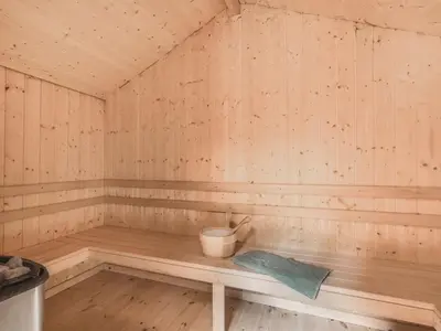 a wooden sauna with a bucket on a bench at Holiday Home Velika - 300m to the fjord by Interhome in Roslev