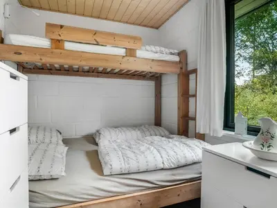 a bedroom with a bunk bed and a window at Holiday Home Velika - 300m to the fjord by Interhome in Roslev