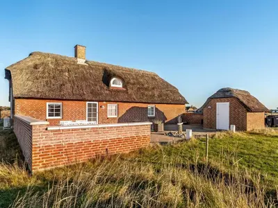 an old brick house with a thatched roof at Holiday Home Amber - 300m from the sea by Interhome in Harboør