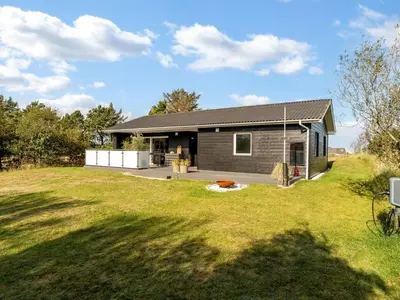 a house with a large yard in front of it at Holiday Home Sarika - 500m from the sea by Interhome in Fjerritslev