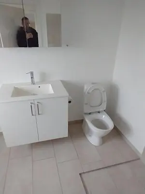a man taking a picture of a bathroom with a toilet at Apartment with water views in Fjerritslev