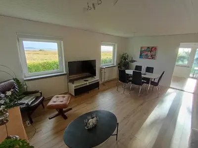 a living room with a television and a table and chairs at Apartment with water views in Fjerritslev