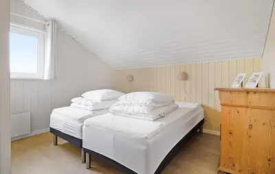 two twin beds in a small room with a window at Cozy Home In Løgstør With Sauna in Løgstør