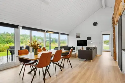 a dining room and living room with a table and chairs at JB362-Brovst-Kronvildtvej-136 in Brovst