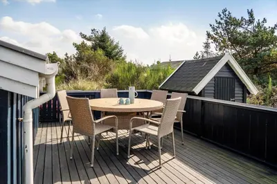 a patio with a table and chairs on a deck at 1334-Thisted-Ingerslevvej-14 in Thisted