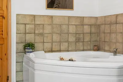a white tub in a bathroom with a tiled wall at 852-Bedsted-Thy-Istrupvej-35 in Bedsted Thy
