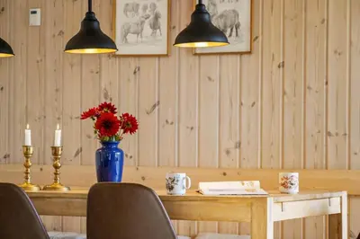 a dining room table with a blue vase with red flowers at 852-Bedsted-Thy-Istrupvej-35 in Bedsted Thy