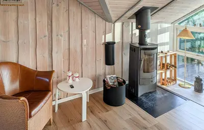 a living room with a wood stove and a chair at Amazing Home In Spøttrup With House A Panoramic View in Spottrup